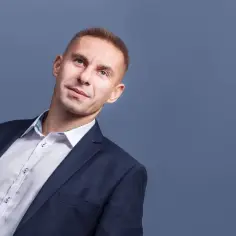 Mężczyzna w garniturze i białej koszuli, patrzący w górę.
