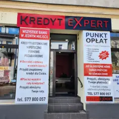 Elewacja biura "Kredyt Expert" z banerami informującymi o ofertach kredytowych i punktem opłat.